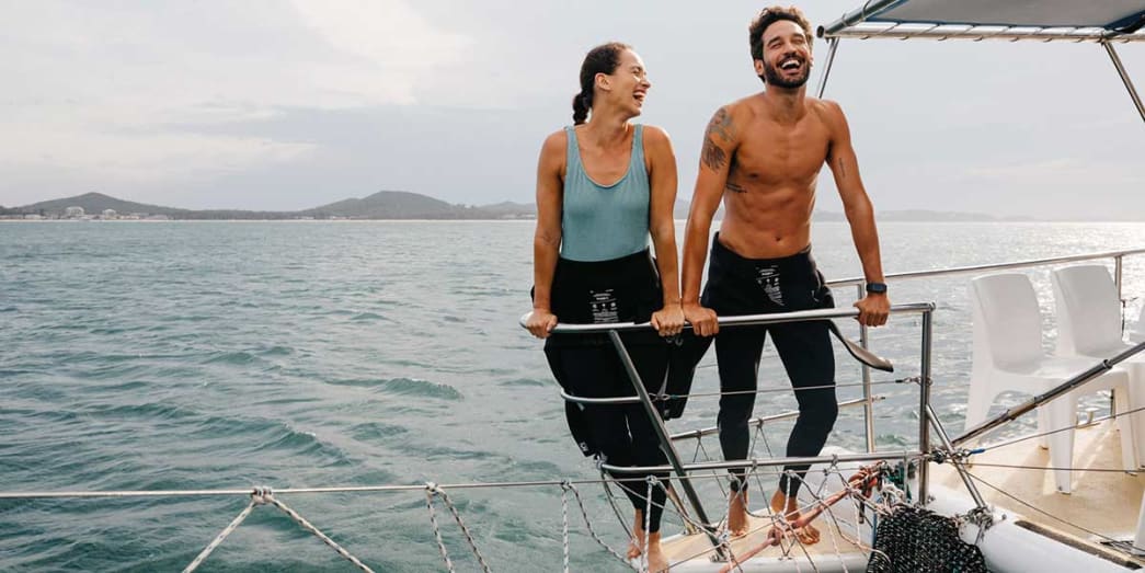 Couples enjoying the moment as they watch the playful dolphins swim in the sea of Port Stephens New South Wales