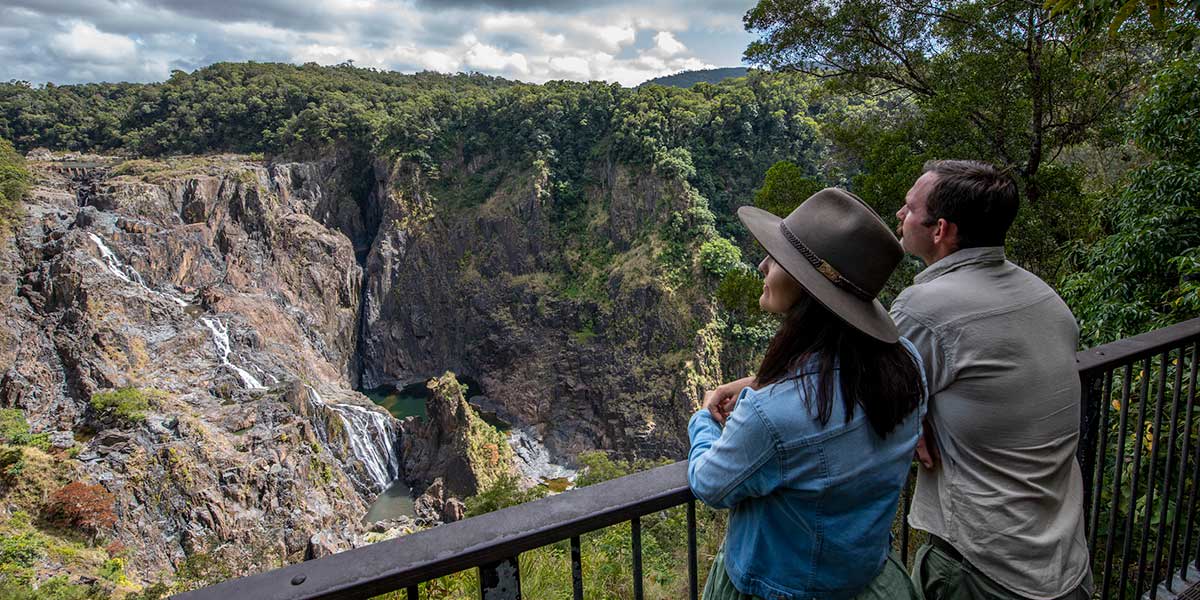 Tourists unwinding through the lush forest on the elevated walkway seeing the Din Din Barron Falls