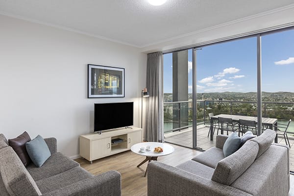 comfortable living room connected to a spacious balcony with nice brisbane city view at oaks 212 margaret 4 bedroom brisbane hotel