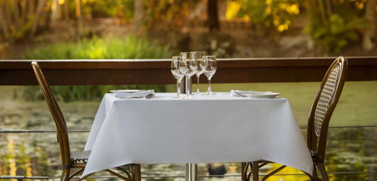 romantic table setting with 2 chairs at table next to fishpond at sunset at popular Reflections Restaurant and Bar in Caloundra on Sunshine Coast, Queensland, Australia