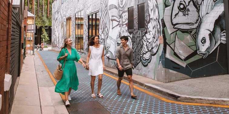 Friends walking along Fish Lane, a home to some of the city’s best casual restaurants and wine bars.