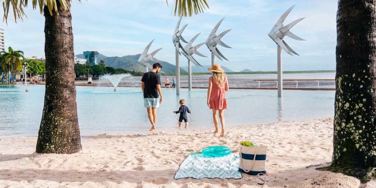Family enjoying vacation at the Cairns Esplanade Lagoon with white fine sand and clean blue waters