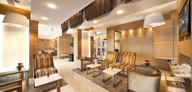 friendly, English speaking hotel reception staff welcome guests in lobby of Oaks Liwa Executive Suites in Abu Dhabi, United Arab Emirates