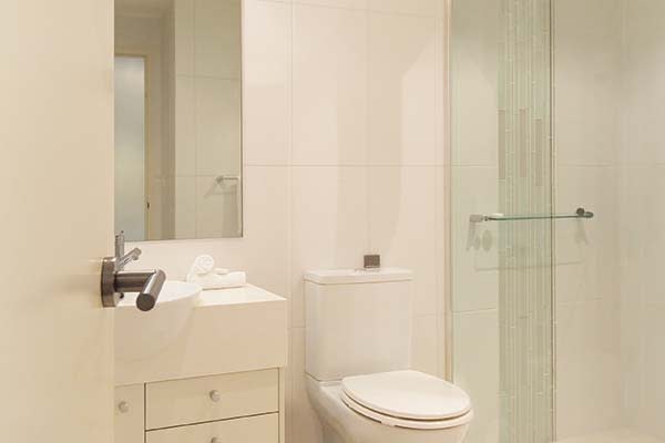 studio apartment bathroom with shower and toilet at oaks pacific blue resort in port stephens