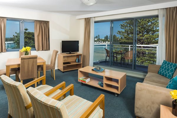 lounge area leading out to balcony with views of The Entrance ocean and Tuggerah Lake