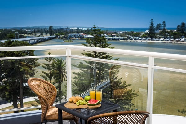 Central Coast hotels with view of ocean from hotel studio apartment sunny balcony with chairs and full breakfast on table