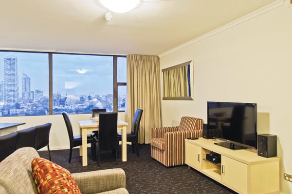 4 star, 2 bedroom apartment in Hyde Park hotel with flat screen TV, couches and view of Sydney city