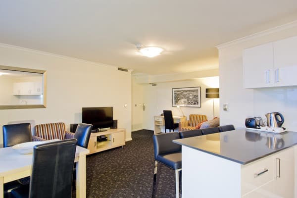 open plan kitchen and living room area in 2 bedroom hotel apartment in Hyde Park, Sydney city centre