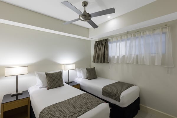 two single beds with ceiling fan and air conditioning in Darwin hotel 2 bedroom apartment