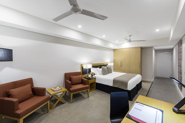 Darwin hotel room with air conditioner, ceiling fan, queen size bed and views of harbour