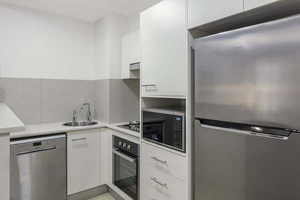 fully equipped kitchen with stove, washing machine, fridge and microwave at 1 Bedroom executive apartment of Oaks 212 Margaret brisbane hotel