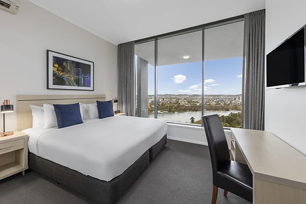 king-sized bedroom with nice brisbane city view and a study desk at oaks 212 margaret 4 bedroom brisbane hotel