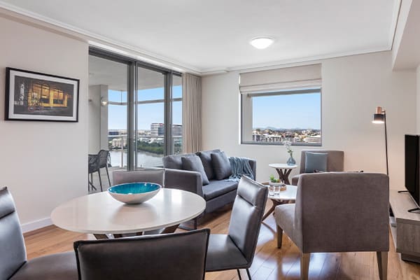 Spacious living and dining room connected to a spacious balcony at Oaks Brisbane Casino Tower Suites one bedroom executive