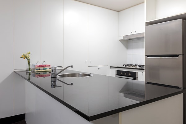 modern kitchen with fridge, oven and large cupboards in 2 bedroom apartment in Brisbane city