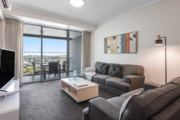 air conditioned living room area with sofa and TV  in 2 bedroom apartment at Oaks Felix hotel in Brisbane CBD