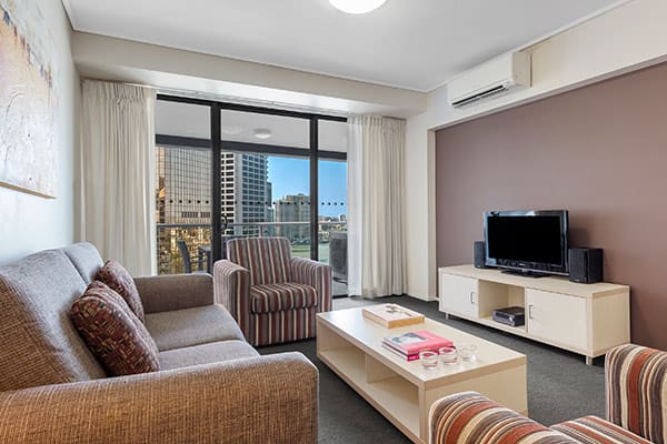 Living room with city view at Oaks Brisbane on Felix Suites 2 Bedroom Story Bridge View 