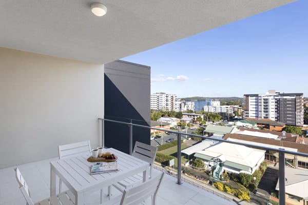 hotel balcony with furniture and views of Brisbane walking distance to The Gabba stadium