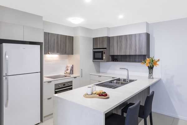 1 bedroom apartment with kitchen that has large fridge and microwave at Oaks Woolloongabba hotel