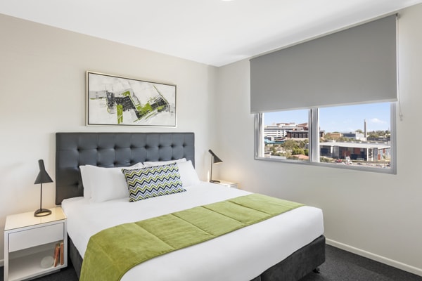 2 bedroom apartment with comfortable double bed and side lamps at Oaks Woolloongabba hotel Brisbane