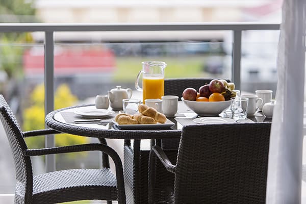 healthy breakfast on table on balcony of 2 bedroom apartment at Oaks Carlyle hotel in Mackay