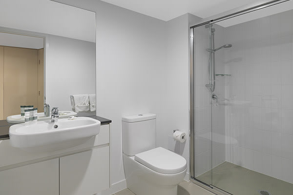 3 bedroom apartment en suite bathroom with shower, toilet and clean towels at Oaks Carlyle hotel in Mackay, Queensland