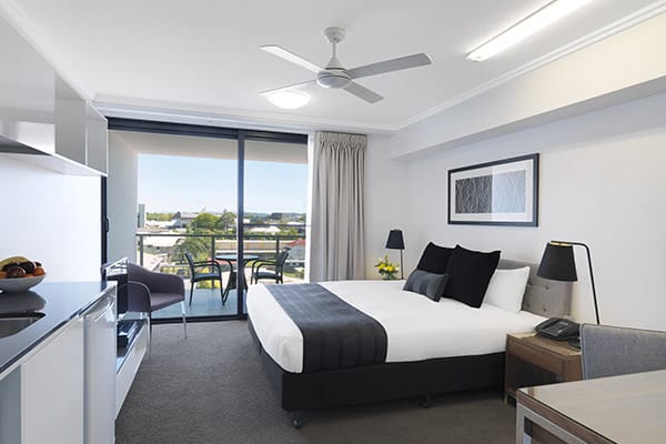 hotel room near Harbour Beach in Mackay with air con, queen size bed and balcony at Oaks Carlyle