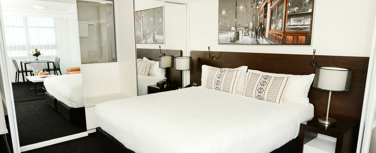 Accommodation Gladstone QLD with queen size bed in 1 bedroom executive apartment with air con, full length mirror and lots of storage space at Oaks Grand Gladstone