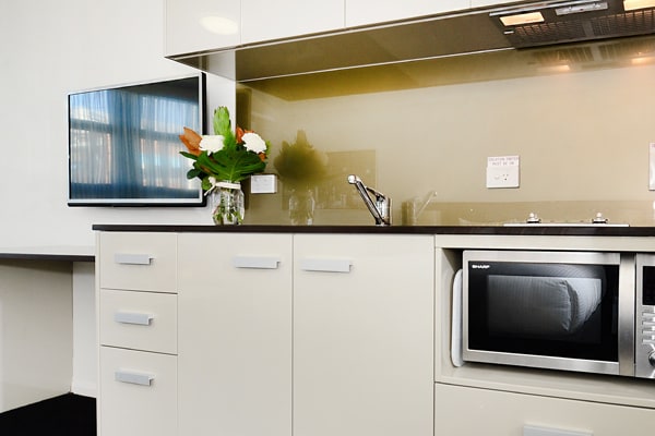 modern kitchen in one bedroom apartment with microwave and television at Oaks Grand Gladstone hotel