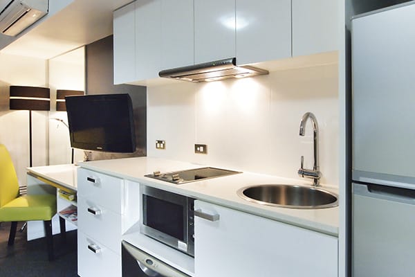 Hotels Townsville kitchen with large fridge and microwave in air conditioned studio apartment at Oaks Metropole Hotel in Townsville