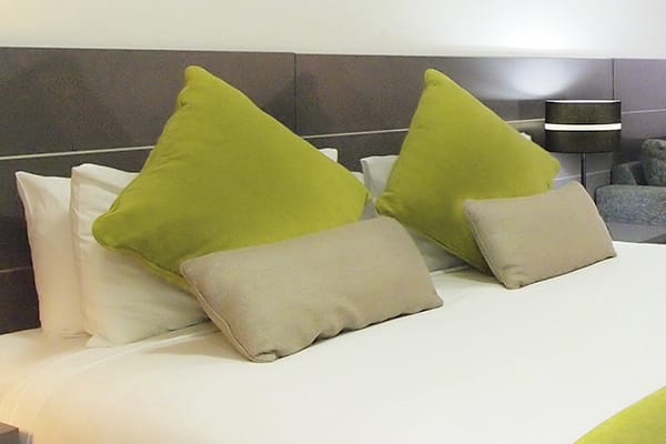 Comfortable queen size bed in studio apartment at Oaks Metropole Hotel near Townsville Airport