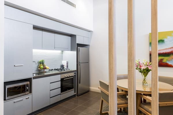 kitchen in 1 bedroom apartment with fridge, oven and microwave at Mon Komo Hotel in Redcliffe