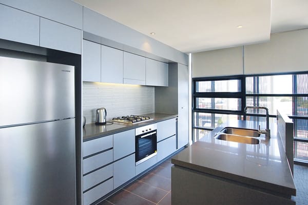 spacious kitchen with large fridge, oven and microwave in 2 bedroom ocean view apartment near beach in Redcliffe