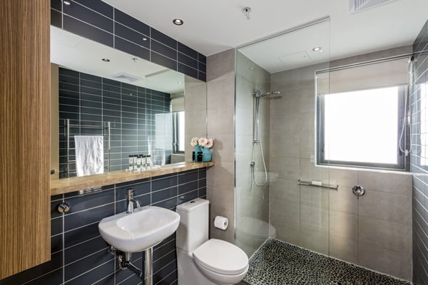 large shower and toilet in en suite bathroom of 3 bedroom apartment at Mon Komo Hotel in Redcliffe