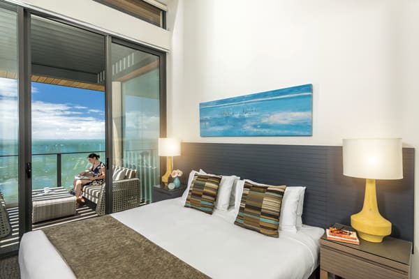 comfortable queen size bed in master bedroom of 3 bedroom apartment with private balcony at Mon Komo Hotel in Redcliffe