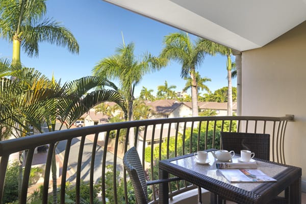 private balcony with table and chairs in one bedroom executive apartment at Oaks Oasis Resort hotel in Caloundra, Sunshine Coast