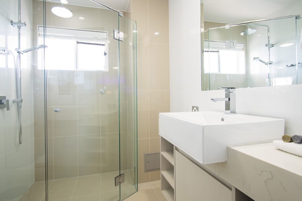 en suite bathroom with large adjustable shower, mirror and toilet in 1 bedroom executive apartment at Oaks Oasis Resort hotel in Caloundra, Sunshine Coast