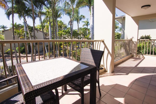 large private balcony in afternoon with table and chairs and views of Oaks Oasis Resort hotel in Caloundra, Sunshine Coast