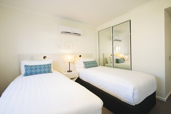 two single beds in air conditioned 2 bedroom apartment with wi-fi and full length mirror