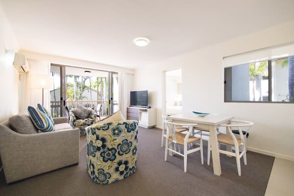 large living room area with air conditioning and television with Foxtel and private balcony outside