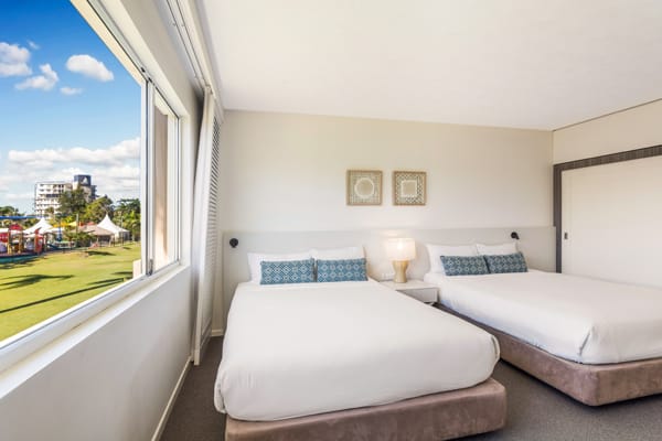 two double beds and large windows with beautiful beach views outside in family friendly Executive Family hotel room bedroom at Oaks Oasis Resort in Caloundra on Sunshine Coast, Queensland, Australia