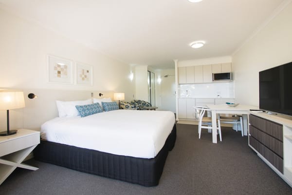 big bedroom with air conditioning, TV with Foxtel and en suite bathroom in Executive King hotel room apartment at Oaks Oasis Resort in Caloundra on Sunshine Coast QLD