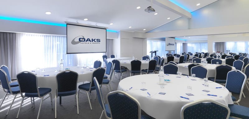 big conference venue ready for event with microphone, projector, tables and chairs at Oaks Oasis Resort in Caloundra on Sunshine Coast, Queensland, Australia