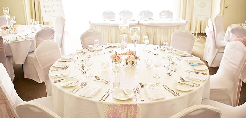 beautiful wedding table setting with cutlery and roses in vase in Caloundra on Sunshine Coast, Queensland, Australia