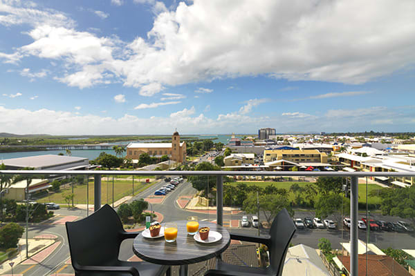 fresh fruit and breakfast on table on balcony of one bedroom apartment with views of Mackay at Oaks Rivermarque hotel