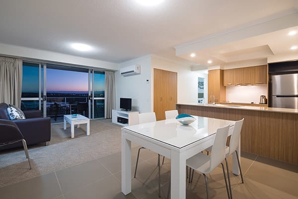 open plan living room with air conditioning, comfortable furniture and TV in two bedroom apartment at Oaks Rivermarque hotels in Mackay, Queensland, Australia