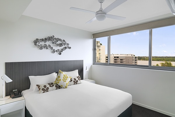 air conditioned bedroom with ceiling fan and Wi-Fi for guests staying in a two bedroom apartment at Oaks Rivermarque hotel in Mackay, Queensland, Australia