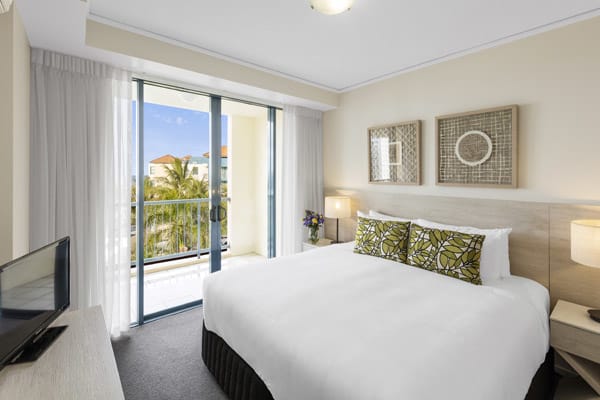 Sunshine Coast hotels air conditioned bedroom with queen size bed, TV and private balcony with views of ocean and beach in 1 bedroom apartment at Oaks Seaforth Resort hotel, Sunshine Coast, Queensland, Australia