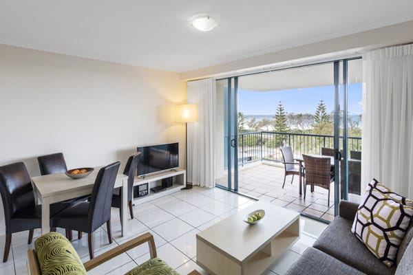 living room in one bedroom hotel apartment with W-Fi and sliding doors leading to balcony with views of ocean