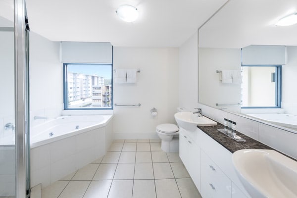 large en suite bathroom in air conditioned 2 bedroom apartment with toilet, shower and clean towels at Oaks Seaforth Resort hotel, Sunshine Coast