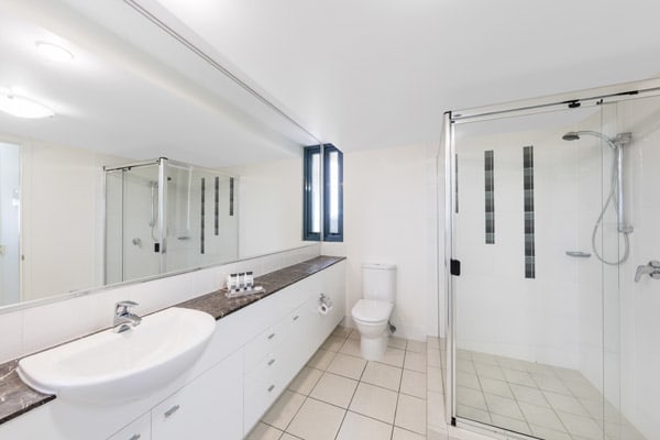 large shower and toilet in en suite bathroom of family friendly 3 bedroom apartment at Oaks Seaforth Resort hotel, Alexandra Headlands, Sunshine Coast, Australia